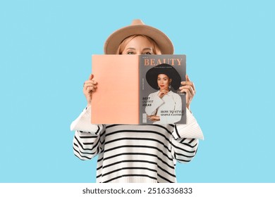 Beautiful mature woman with magazine on blue background - Powered by Shutterstock