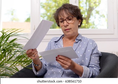 beautiful mature woman opens the mail at home