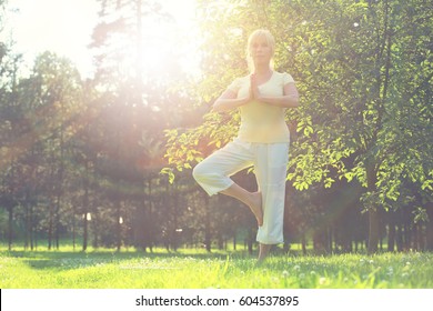 Beautiful Mature Woman Practice Yoga In Summer Park