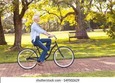 Beautiful Mature Woman Riding A Bike At The Park