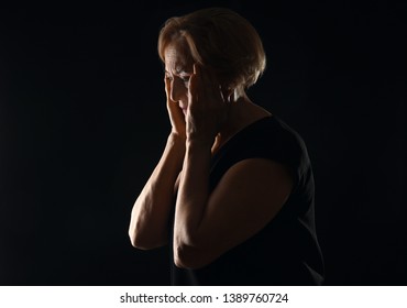 Beautiful Mature Woman Suffering From Head Ache On Dark Background