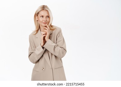 Beautiful Mature Woman Thinking, Looking With Pleased Smile And Thoughtful Face, Wearing Stylish French Coat, Standing Over White Background