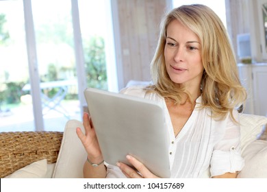 Beautiful Mature Woman Using Electronic Tablet At Home