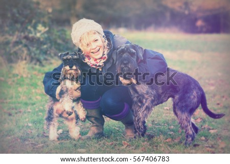 Similar – Image, Stock Photo Blond woman with her two dogs in the countryside