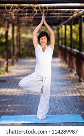 Beautiful Mature Woman Yoga Pose In Garden