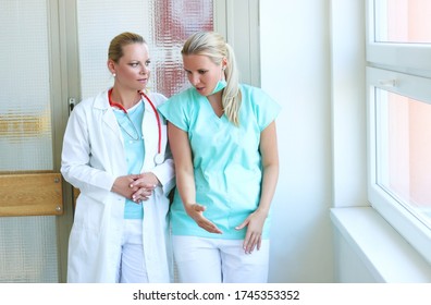 Beautiful medical doctors with stethoscope and protective equipment dressed white coat discussing in the hospital corridor. Education, medicine, science, research, pharmacy and teamwork concept. - Shutterstock ID 1745353352