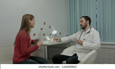 Beautiful medical representative presenting new product to doctor