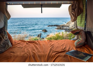 beautiful mediterranean view from a cozy bohemian camper van interior. Unmade bed, pillows, van life theme. Vanlife lifestyle and travel concept/ young people traveling with camper/ restored vehicle - Powered by Shutterstock