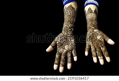 Beautiful Mehendi Design on hands in black background with copy space for text