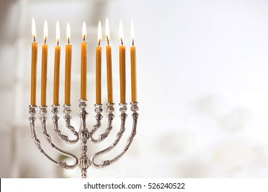 Beautiful Menorah With Burning Candles On Light Blurred Background. Hanukkah Concept