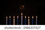 Beautiful Menorah candles during Hanukkah with Star of David on a black background