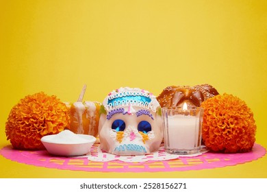 Beautiful Mexican offering for the Day of the Dead with a sugar skull, Bread of the Dead, Aztec Marigold, a pumpkin or squash, salt and a candle on cut traditional paper over a yellow background. - Powered by Shutterstock