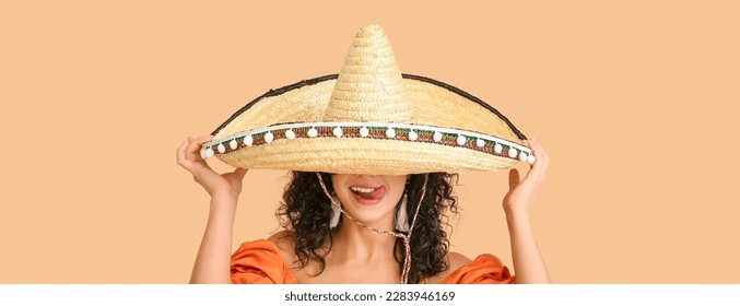 Beautiful Mexican woman in sombrero hat on beige background