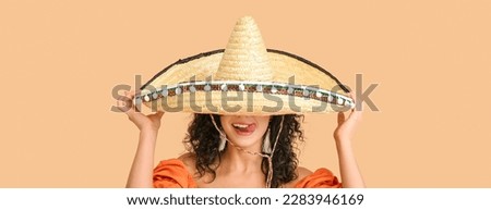 Beautiful Mexican woman in sombrero hat on beige background