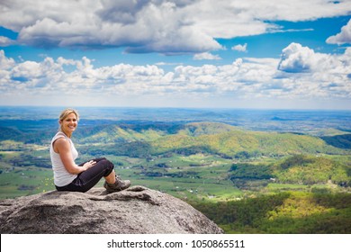 Beautiful Mid 30s Hiker Woman Sitting On A Rock Relaxing On The Old Rag Mountain Trail In Shenandoah Valley National Park In Virginia