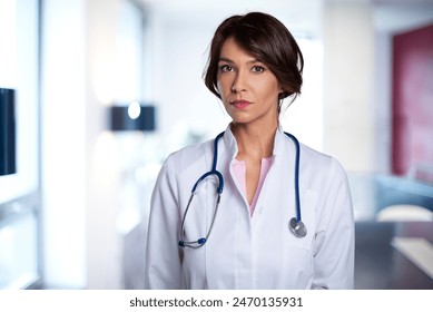 Beautiful mid aged female doctor standing at the clinic. Brown haired woman wearing lab coat and stethoscope around her neck. - Powered by Shutterstock