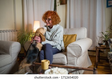 Beautiful Mid Aged Woman Cuddling With Her Dog At Home