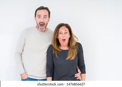 Beautiful Middle Age Couple In Love Over Isolated Background Afraid And Shocked With Surprise Expression, Fear And Excited Face.