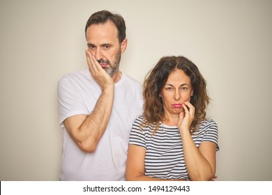 Beautiful Middle Age Couple Together Standing Over Isolated White Background Thinking Looking Tired And Bored With Depression Problems With Crossed Arms.