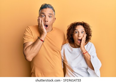 Beautiful Middle Age Couple Together Wearing Casual Clothes Afraid And Shocked, Surprise And Amazed Expression With Hands On Face 