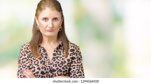 Beautiful Middle Age Mature Rich Woman Wearing Leopard Dress Over Isolated Background Skeptic And Nervous, Disapproving Expression On Face With Crossed Arms. Negative Person.