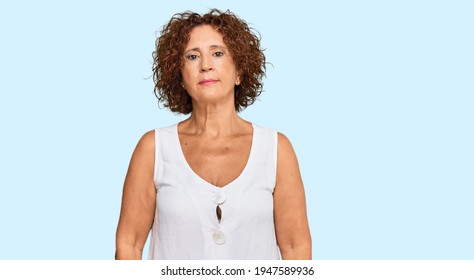 Beautiful Middle Age Mature Woman Wearing Casual White Shirt Relaxed With Serious Expression On Face. Simple And Natural Looking At The Camera. 