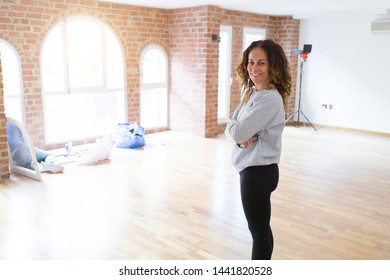 Beautiful Middle Age Woman With Curly Hair Smiling Confident At New Home, Renovating And Painting House