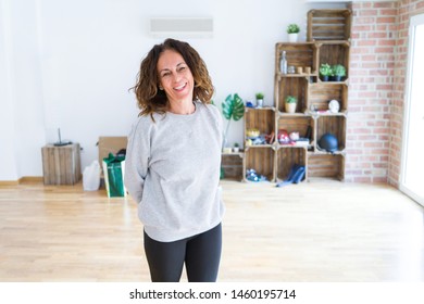 Beautiful Middle Age Woman With Curly Hair Smiling Confident At New Home, Renovating And Painting House