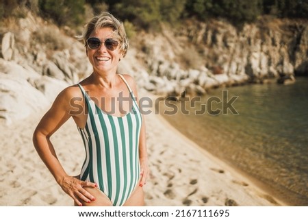 A beautiful middle age woman having fun and enjoying at vacationon the beach.