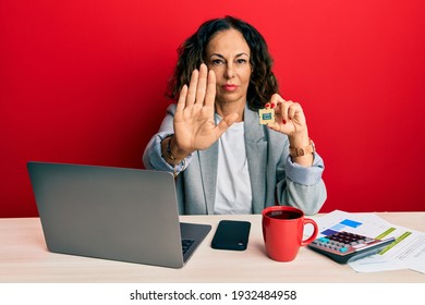 Beautiful Middle Age Woman Holding Cpu Computer Processor With Open Hand Doing Stop Sign With Serious And Confident Expression, Defense Gesture 