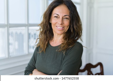 Beautiful middle age woman at home smiling cheerful with arms crossed