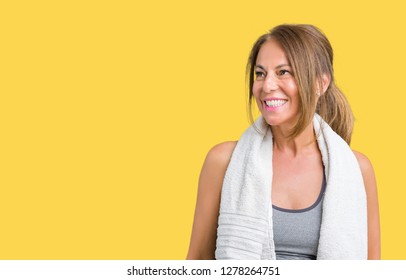 Beautiful Middle Age Woman Wearing Sport Clothes And A Towel Over Isolated Background Looking Away To Side With Smile On Face, Natural Expression. Laughing Confident.