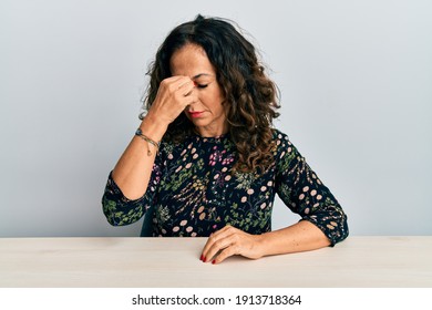 Beautiful Middle Age Woman Wearing Casual Clothes Sitting On The Table Tired Rubbing Nose And Eyes Feeling Fatigue And Headache. Stress And Frustration Concept. 