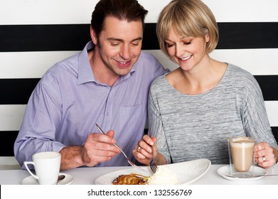 Beautiful Middle Aged Couple Enjoying Coffee And Trying New Cuisine.