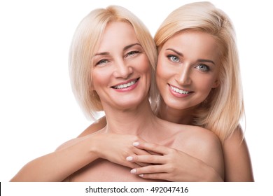 Beautiful middle aged mother and her adult daughter in studio