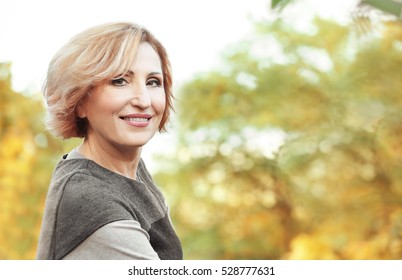 Beautiful Middle Aged Woman In Autumn Park