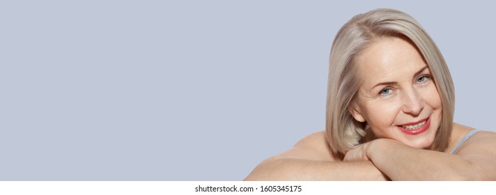 Beautiful middle aged woman fase close up on grey background