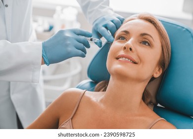 Beautiful middle aged woman get injection in clinic. Cosmetology and beauty concept. Anti-age anti-wrinkle shots with botox botulinum, facial serum for lifting effect. - Powered by Shutterstock