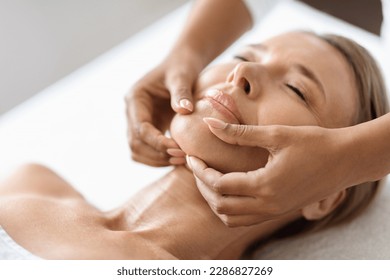 Beautiful Middle Aged Woman Getting Face Lifting Massage In Luxury Spa Salon, Masseur Making Double Chin Treatment Procedure To Relaxed Mature Female Lying With Eyes Closed, Closeup Portrait - Shutterstock ID 2286827269