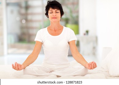 Beautiful Middle Aged Woman Meditation On Bed At Home