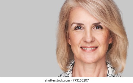 Beautiful Middle Aged Woman With Natural Make Up And Clean Skin. Skincare And Wellness. Isolated On Grey With Copy Space