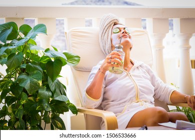 Beautiful Middle Aged Woman Relaxed Outdoors On The Terrace With A Cucumber Face Mask