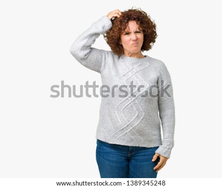 Beautiful middle ager senior woman wearing winter sweater over isolated background confuse and wonder about question. Uncertain with doubt, thinking with hand on head. Pensive concept.