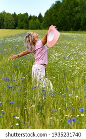 A Beautiful Middle-aged Woman Enjoys Outdoor Recreation, A Walk In The Meadow. Happy 55 Years Old Woman Leading A Healthy Lifestyle. 