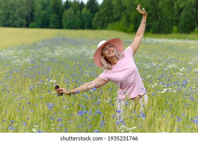 A Beautiful Middle-aged Woman Enjoys Outdoor Recreation, A Walk In The Meadow. Happy 55 Years Old Woman Leading A Healthy Lifestyle. 