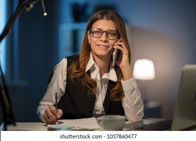 Beautiful middle-aged woman working in the office until the night on overtime