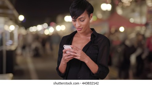 Beautiful Millennial Woman Using Smartphone Texting App And Making A Phone Call At Outdoor Evening Farmers Market