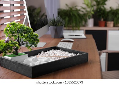 Beautiful miniature zen garden and computer on wooden table in office