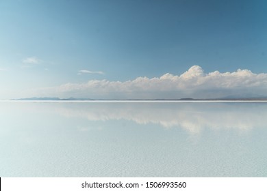 Beautiful mirror reflection on blue sky and cloud on Bolivia's Salt Flats. Shot in Salar de Uyuni salt flat. Water reflection of clouds and empty space. Holiday, vacation, freedom scene with horizon. 