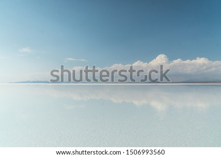 Beautiful mirror reflection on blue sky and cloud on Bolivia's Salt Flats. Shot in Salar de Uyuni salt flat. Water reflection of clouds and empty space. Holiday, vacation, freedom scene with horizon. 